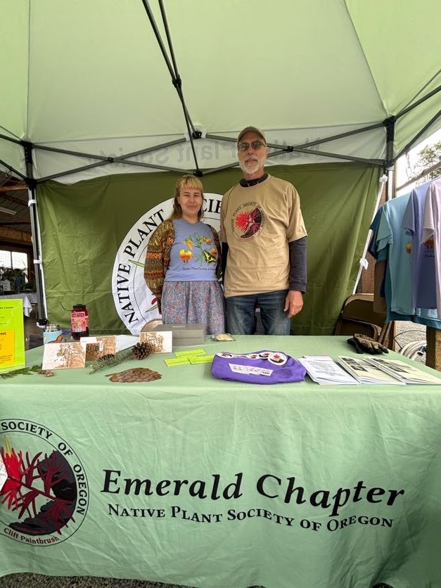 Native Plant Society Members Bruce Waugh and Sarah Erskine standing in their festival stand at the Wildflower Festival.